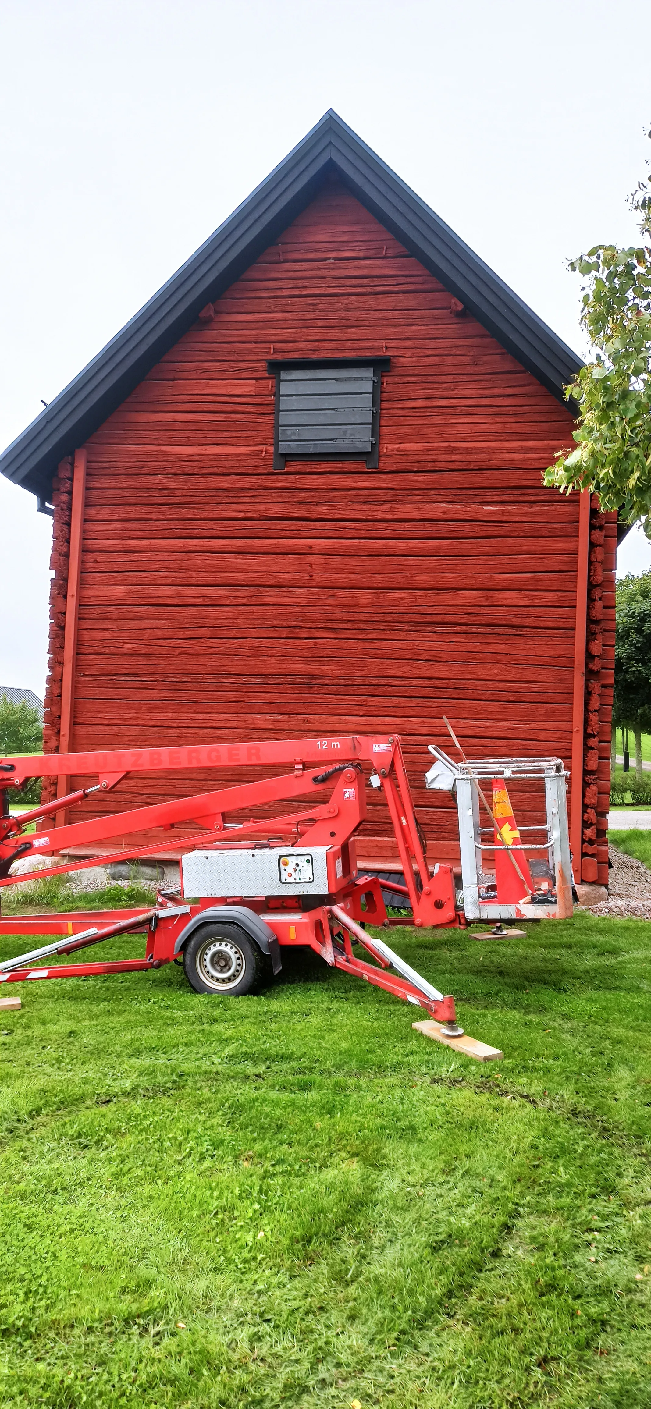 Röd trähus med byggmaskiner och renovering