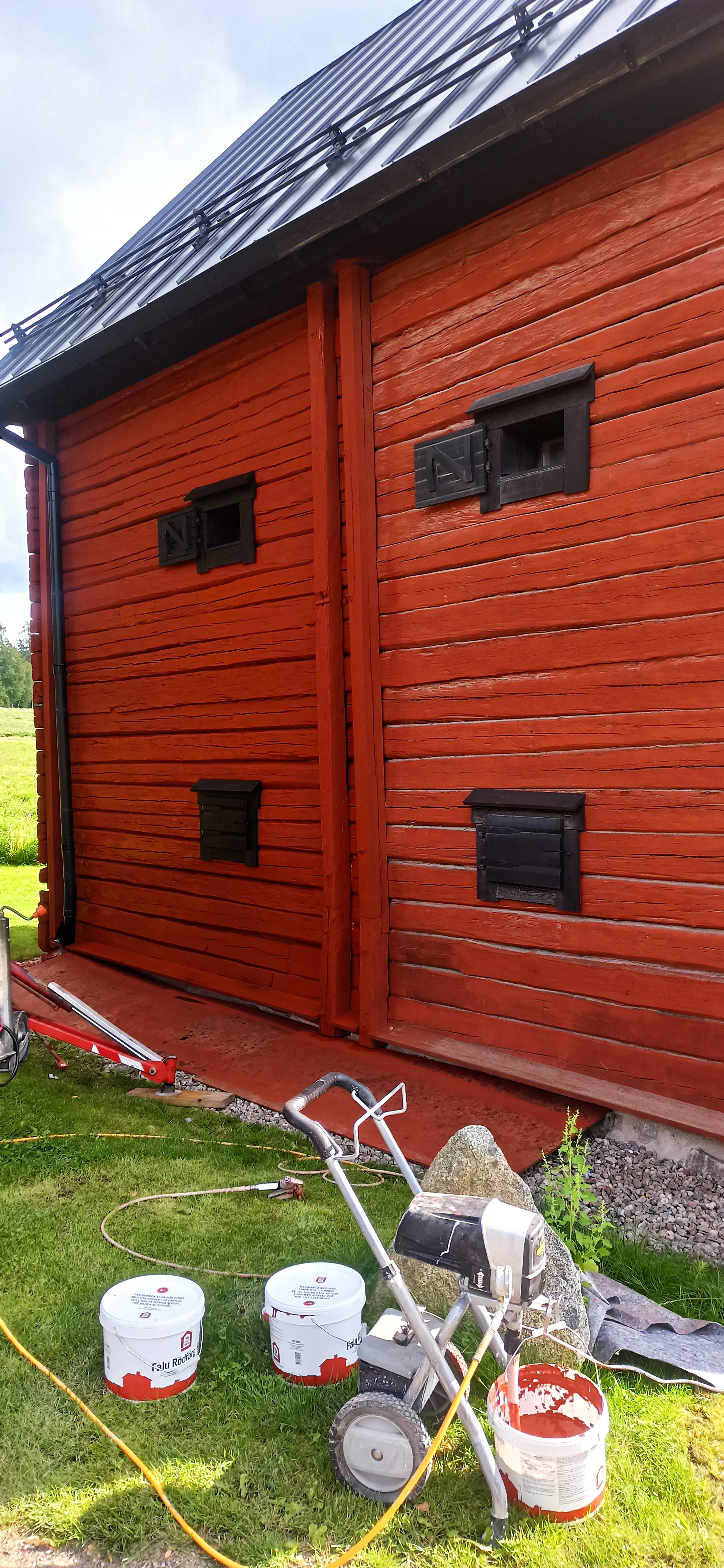 Röd träbyggnad under renovering