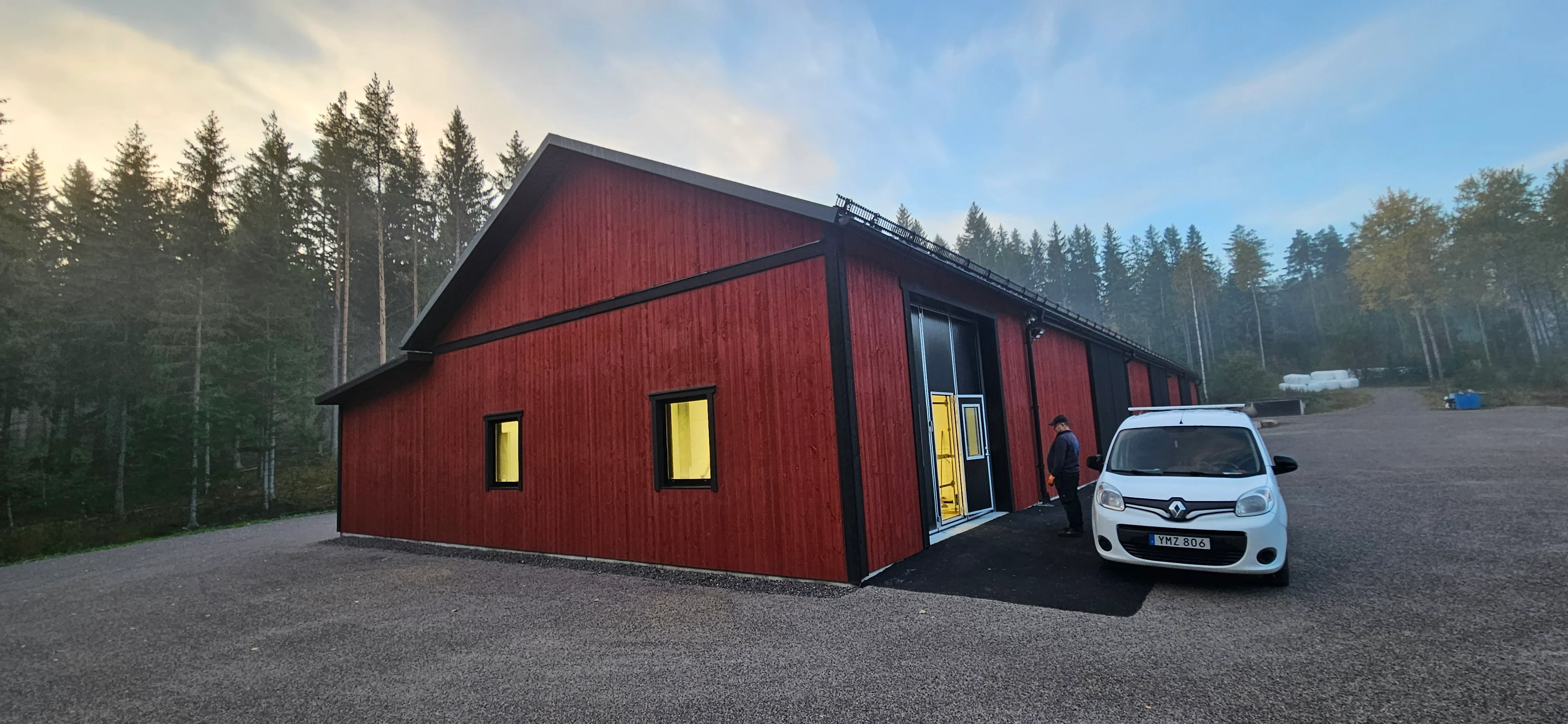 Röd modernt hus omgiven av skog
