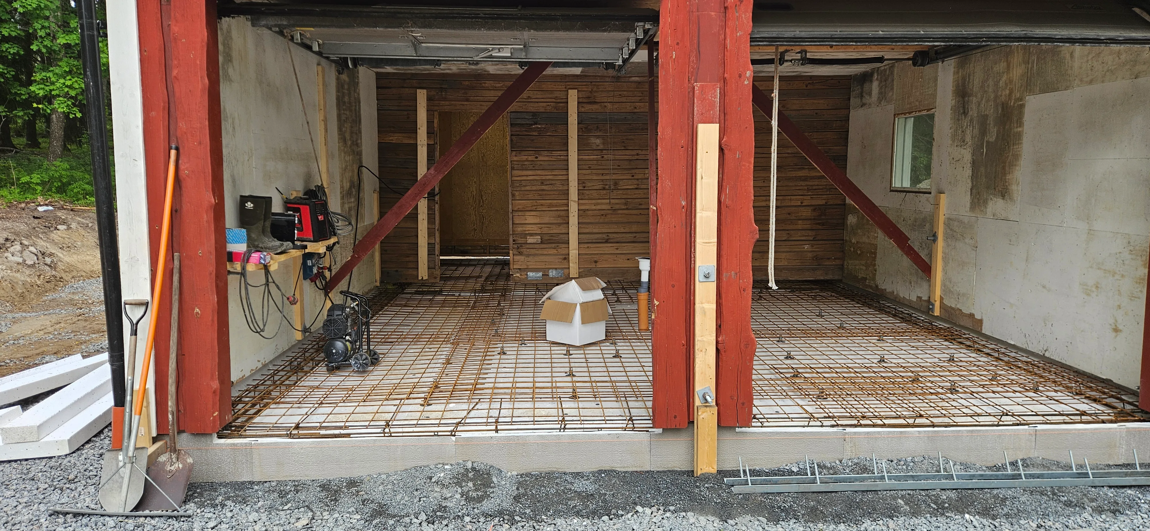 Garage under renovering med röda stålbalkar