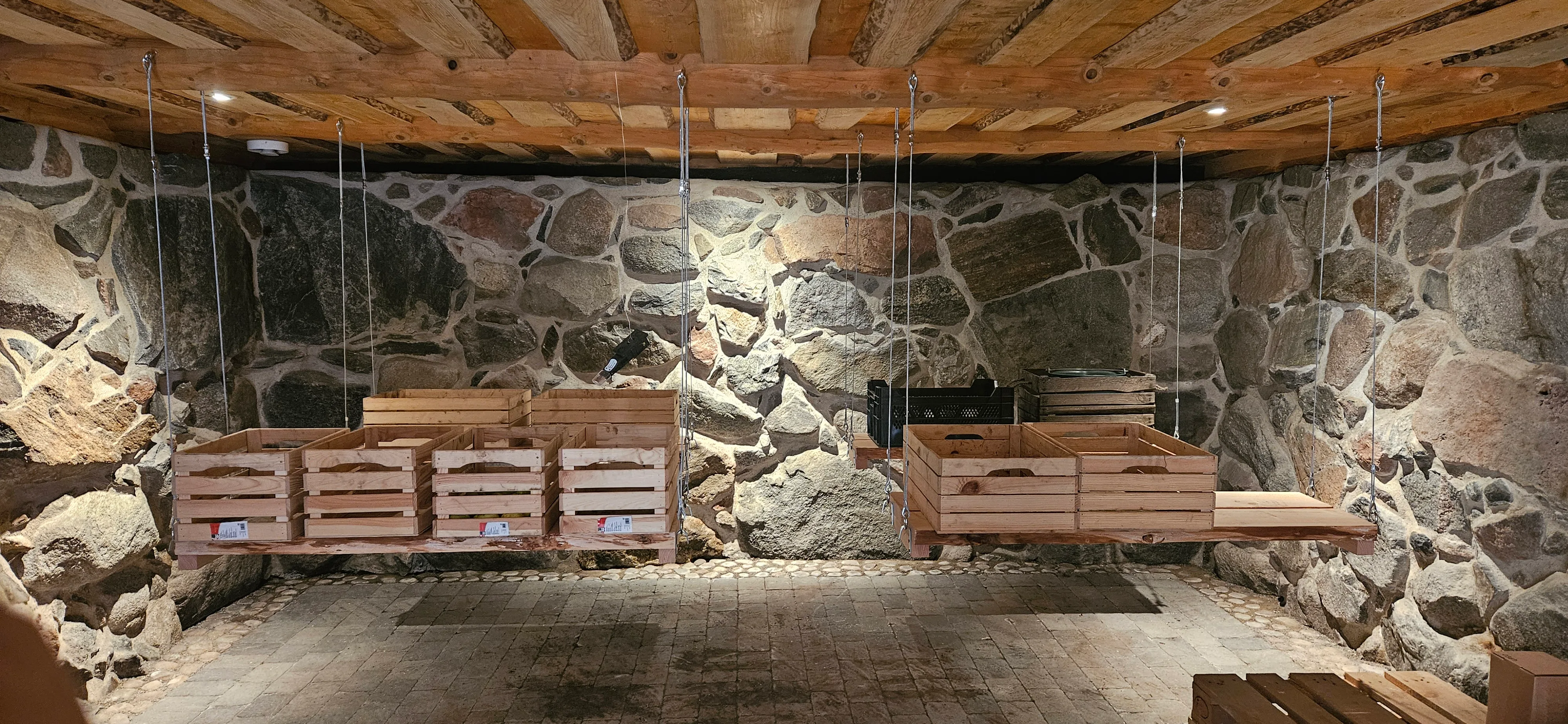 Källarrum med stenvägg och träbänkar