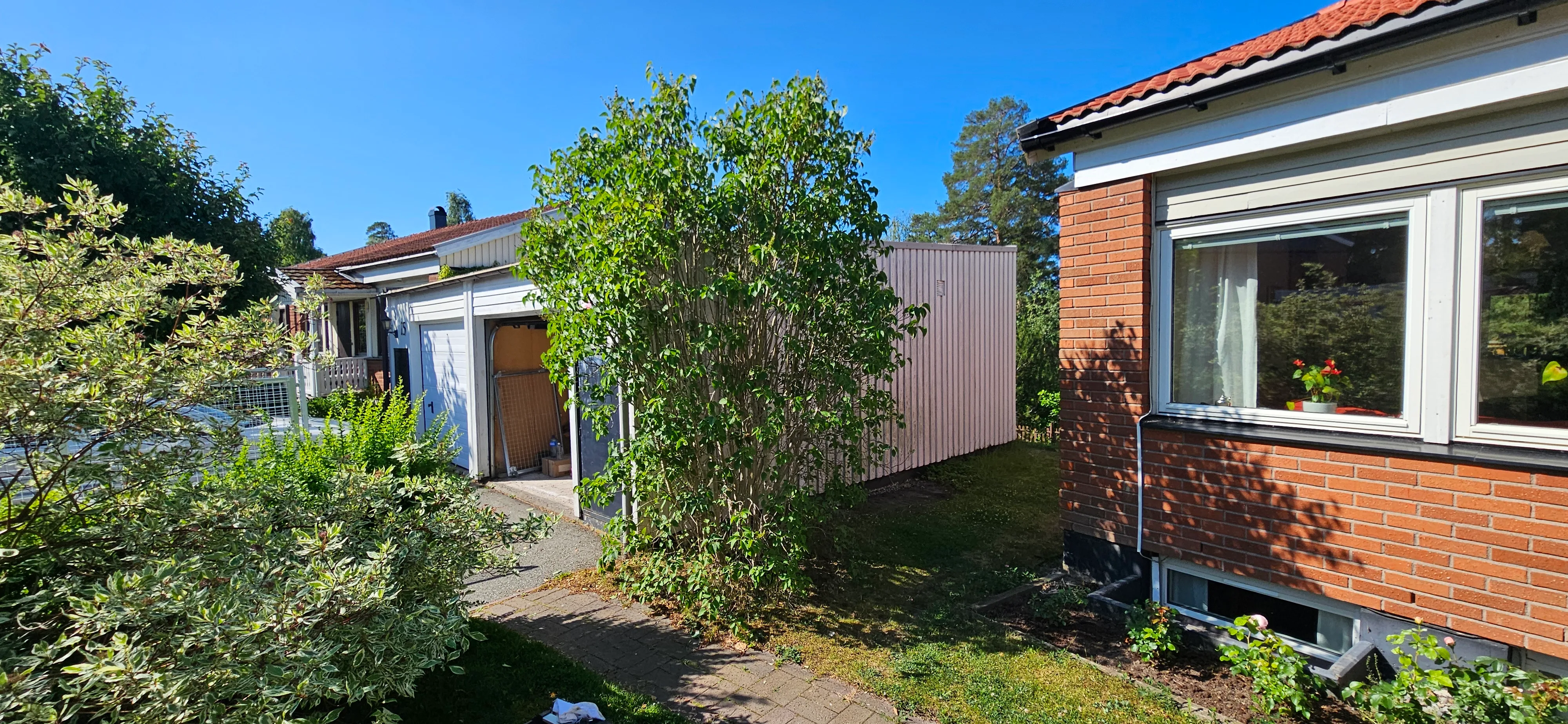 Uteområde med trädgård och byggnadsarbete pågår i bakgrunden