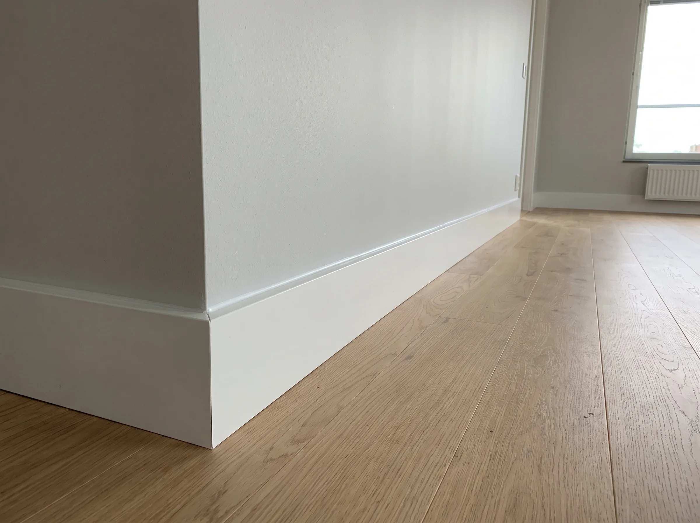 Nyinstallerad golvlister av hög kvalitet i ett rum med trägolv