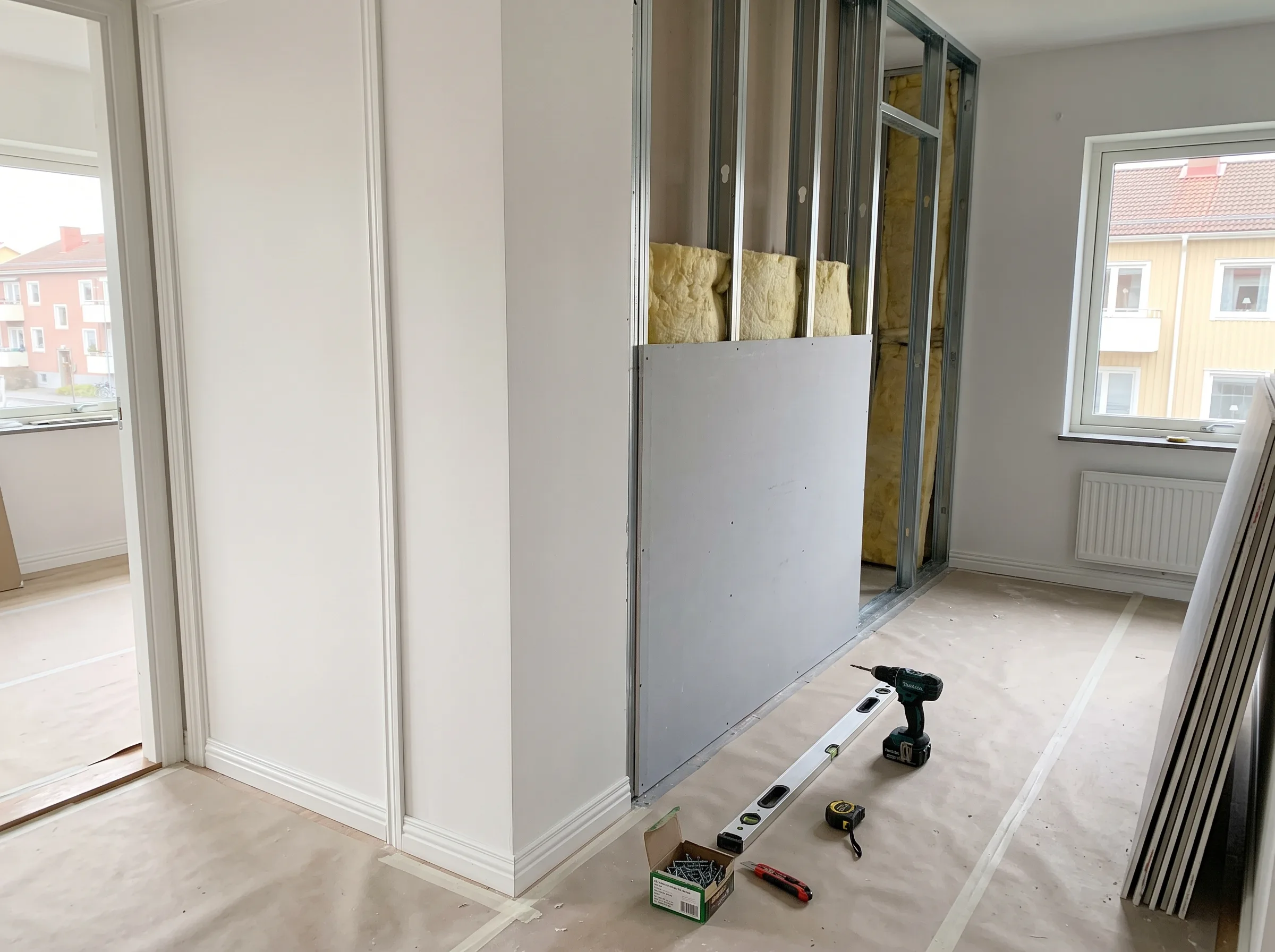Renovering av innerväggar med gips och verktyg synliga i rummet
