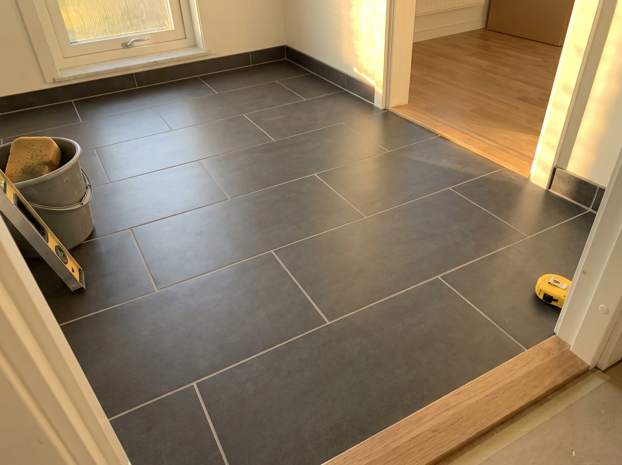 Nya kakelplattor på golvet i ett rum, färdigställande av badrumsrenovering