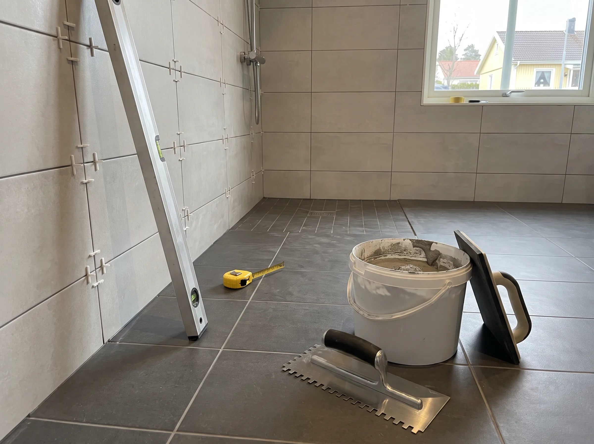 Verktyg och material för badrumsrenovering med kakel och klinker