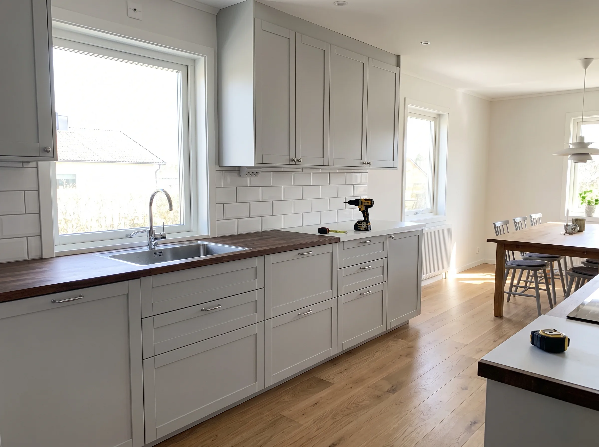 Modernt kök med gråa skåp och en träbänk, förberett för köksrenovering