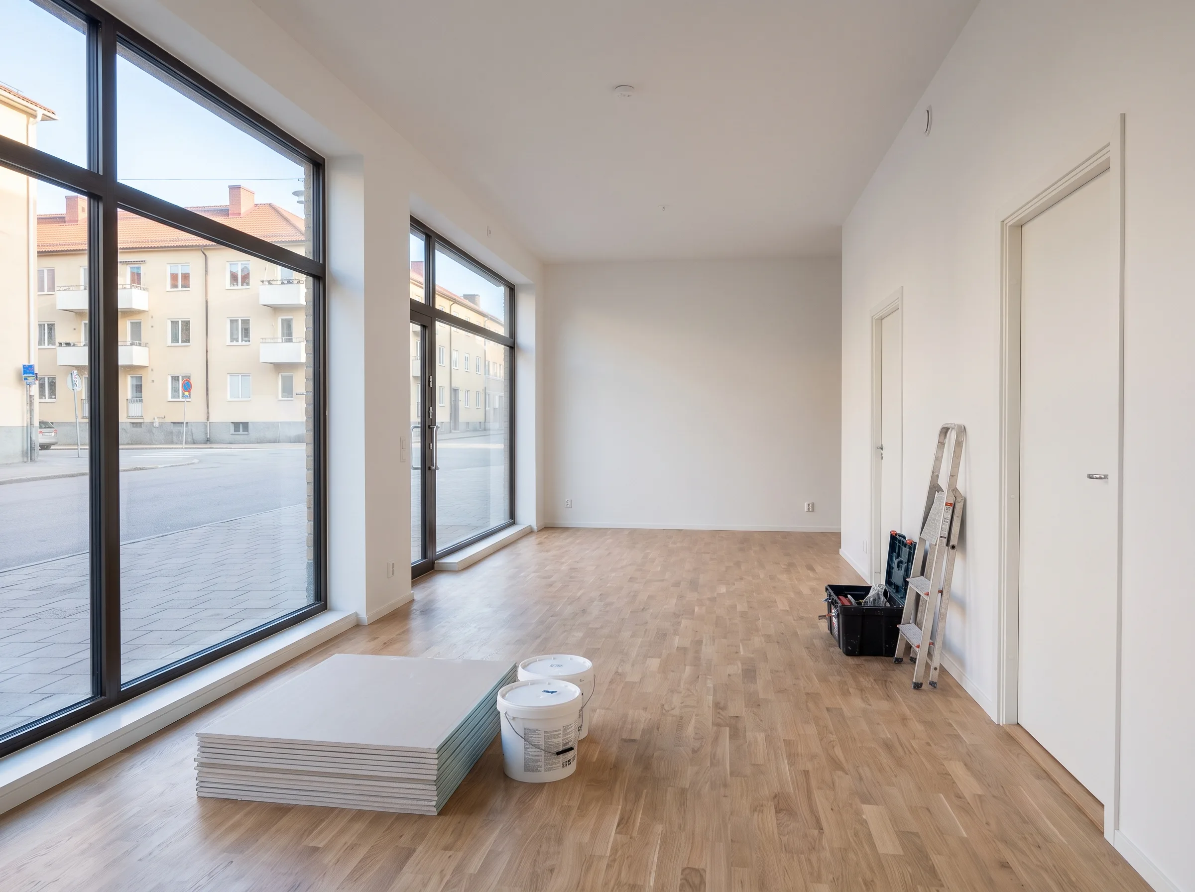 Inredning av lokal med parkettgolv och gipsväggar, redo för renovering