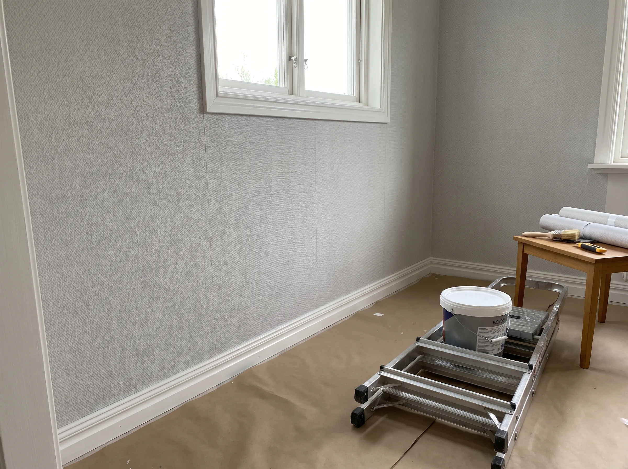 Renovering av innerväggar med tapetsering och målning utförd i ett rum