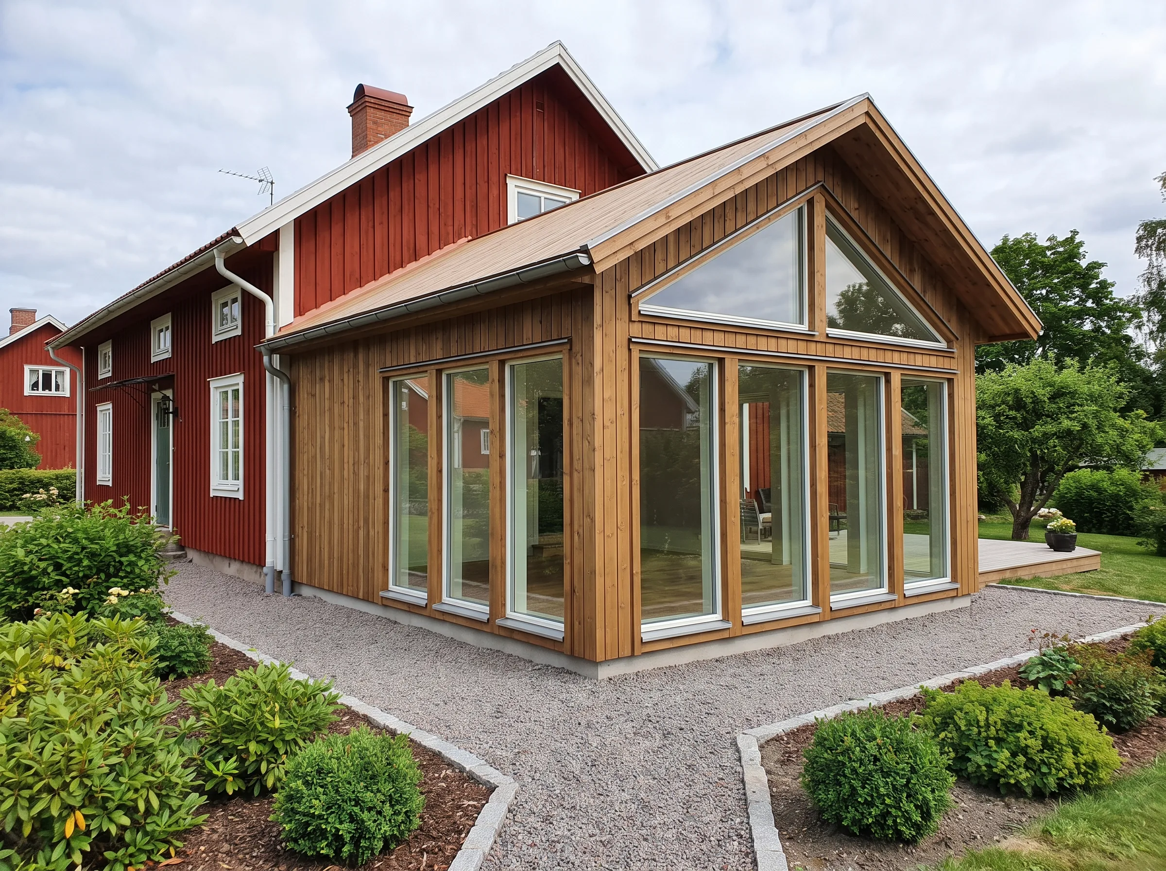 Renoverat hus med stora fönster och träarkitektur i en vacker utemiljö