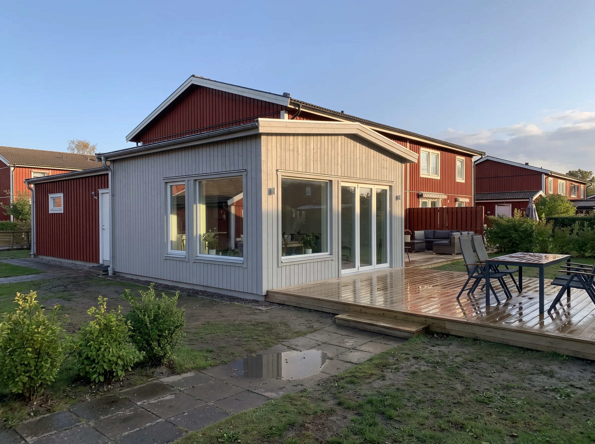 Nyrenoverad byggnad med träterrass och fönster som släpper in ljus